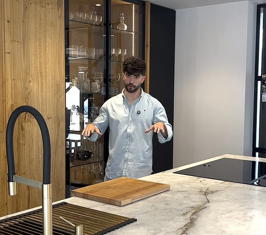 Jorge González Ruiz, de Komad Studio, en una cocina con frentes de roble, vitrina iluminada e isla de piedra natural